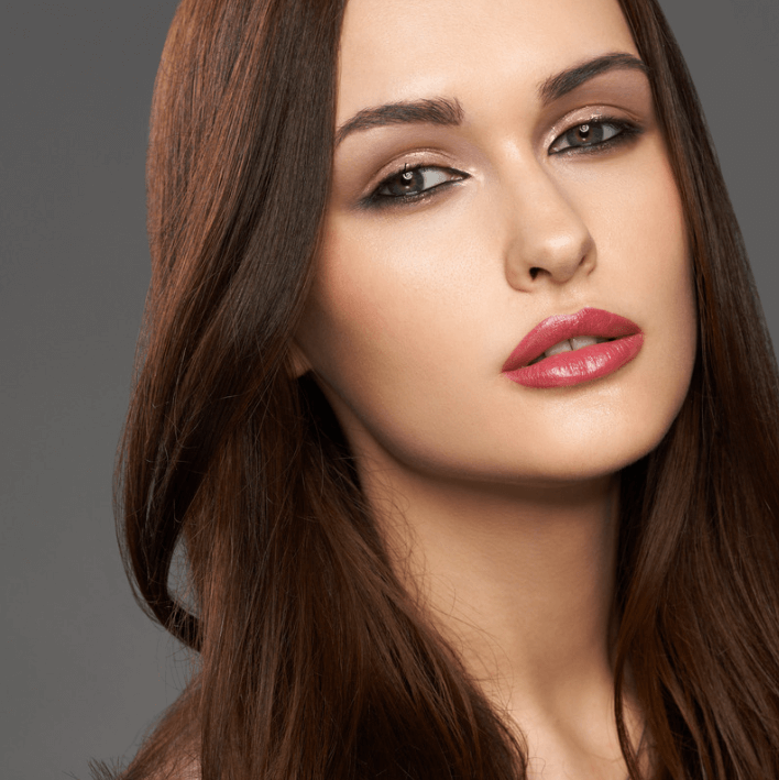 Schöne Frau mit langen, brünetten Haaren und frischem Make-up, ideal für Beauty-Inspiration.