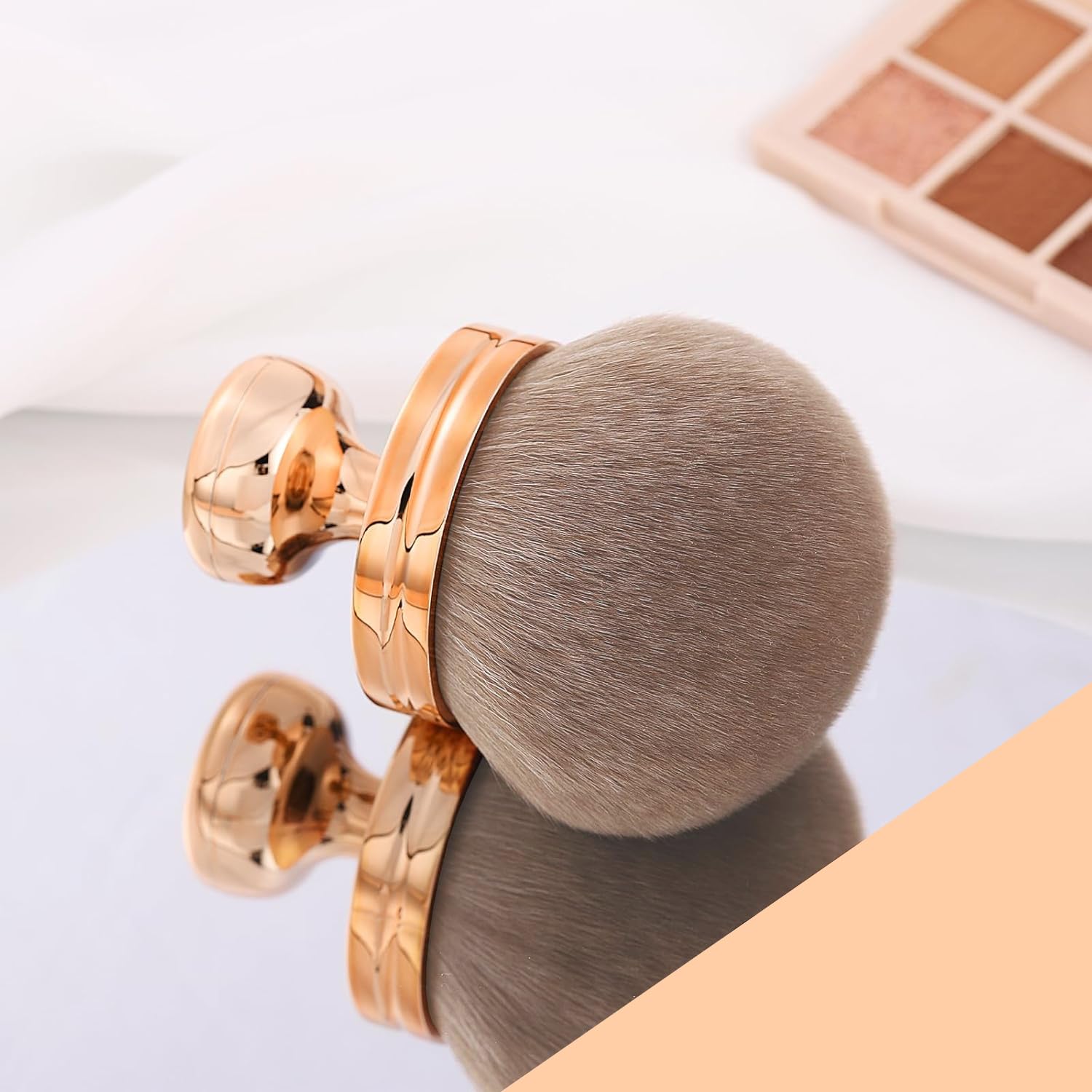 Make-up Pinsel – Kabuki Foundation Brush auf einem Spiegel, mit roségoldener Aluminiumhülse und weichen Borsten.